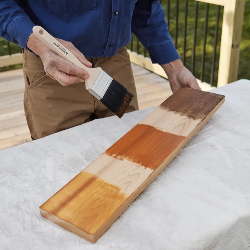 Person staining wood with brush